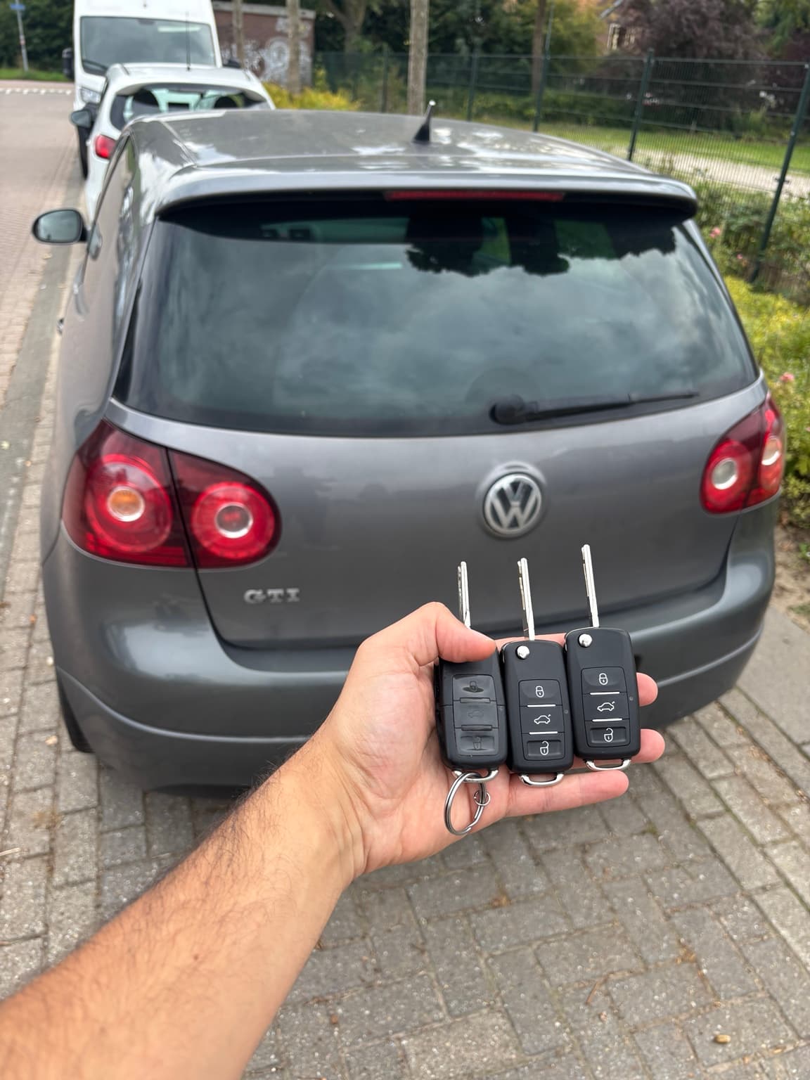 Drie autosleutels van een Volkswagen bij het voertuig