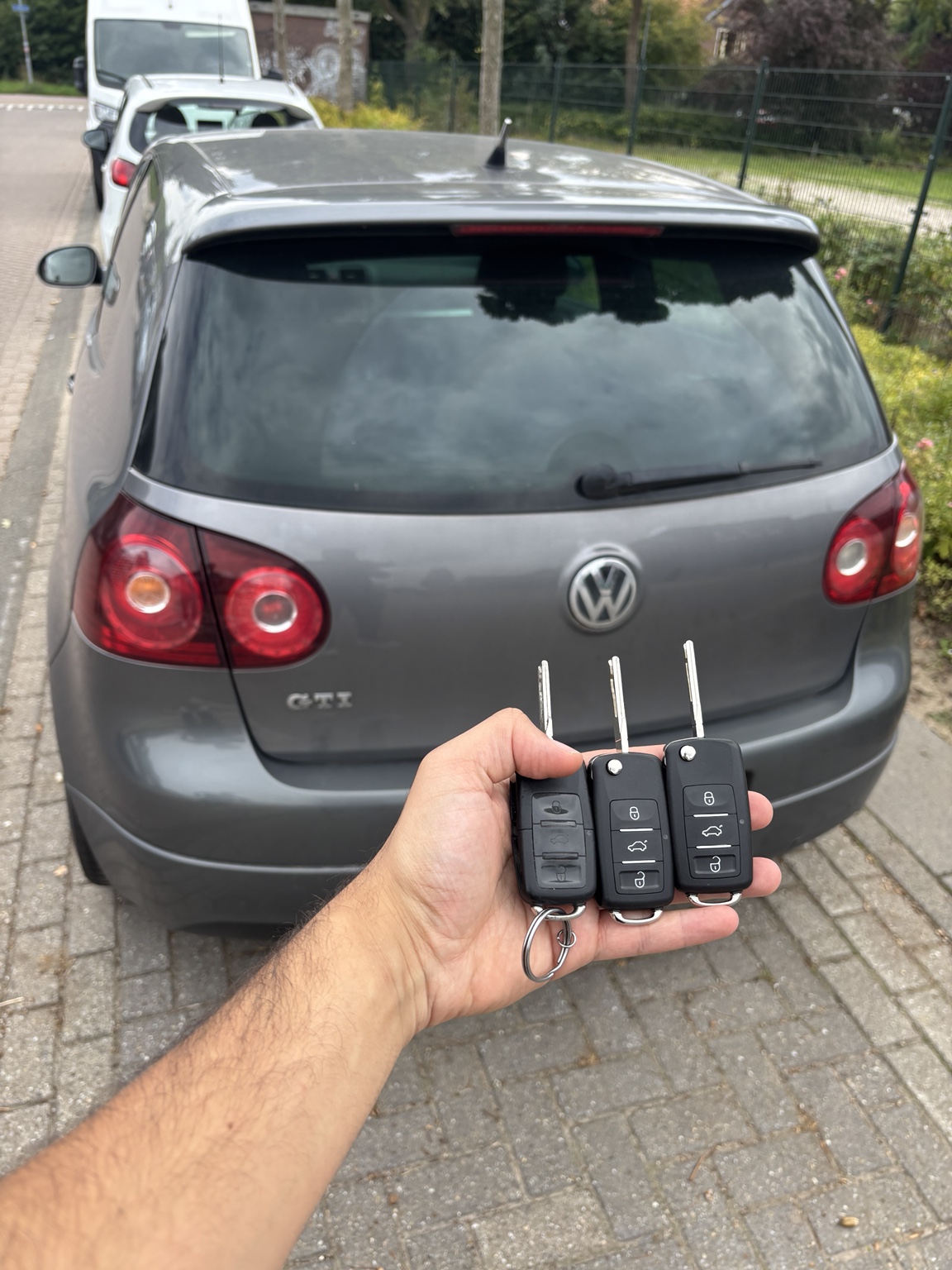 Drie autosleutels van een Volkswagen bij het voertuig